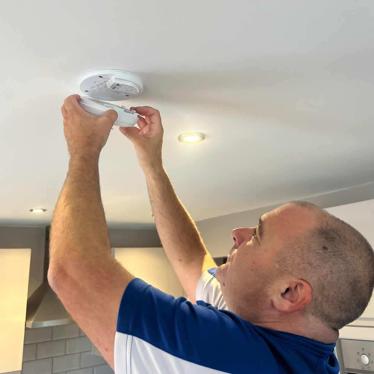 Smoke alarm installer fitting an alarm in a Dundee property